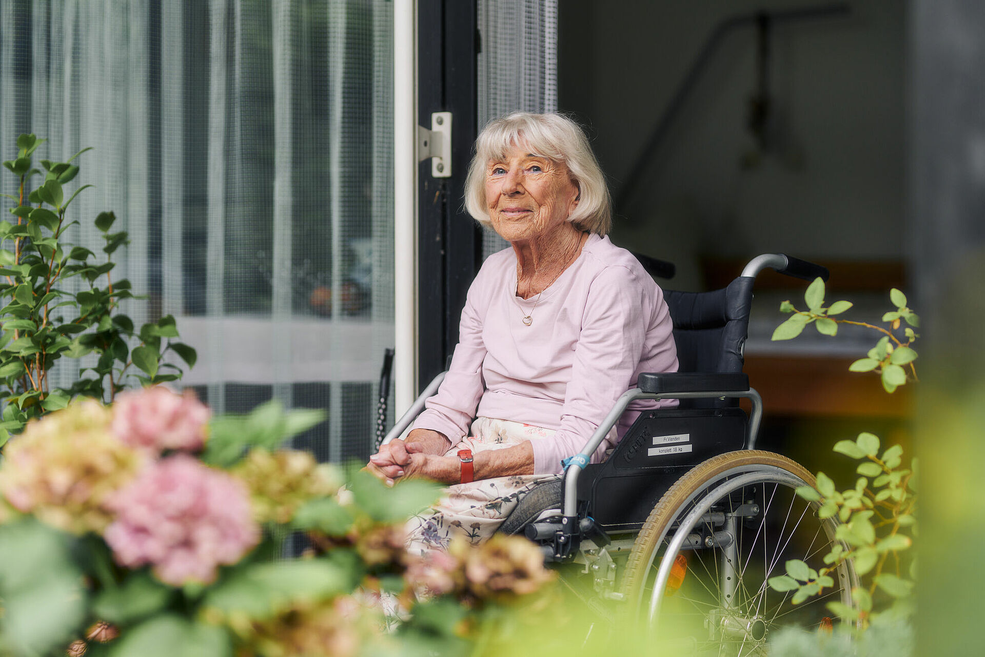 Bewohnerin im Rollstuhl auf der Terrasse